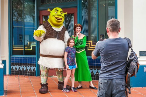Man photographing daughter with Shrek and Princess Fiona at Universal Studios theme park in