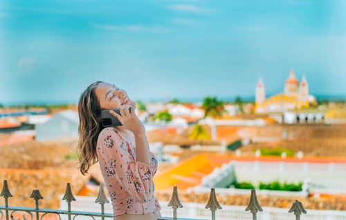 Happy girl talking on the phone at the viewpoint in Granada, Nicaragua. Nicaraguan woman talking on