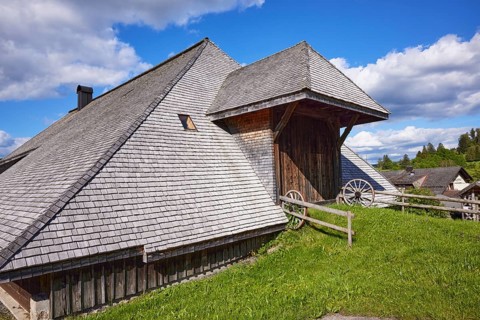 Entrance gate to a Black Forest house with old wagon wheels of the Resenhof Farm Museum in the