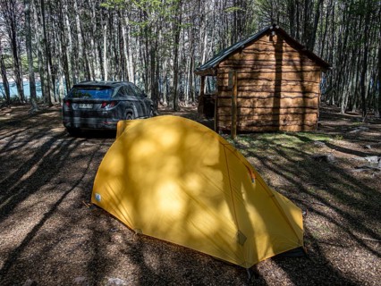 Tent and rental car on campground at the Jeinimeni NP, wooden shelter and sitting area, Patagonia,