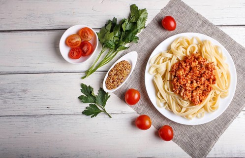 Fettuccine bolognese pasta with minced meat on white wooden background. top view, copy space