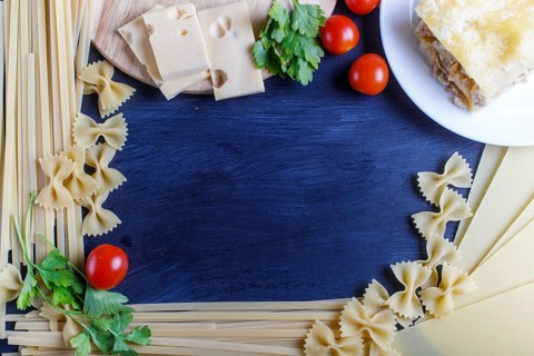 Frame with italian pasta ingredients on black wooden background. copy space, top view
