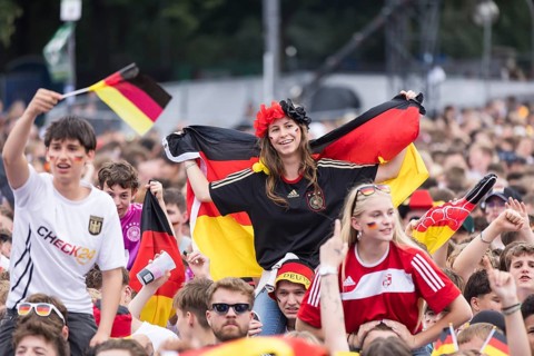Football fans sitting on shoulders in the fan zone at the Brandenburg Tor during the quarter-final