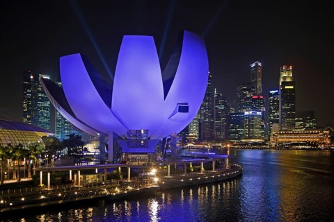 The purple illuminated ArtScience Museum and skyline with skyscrapers and high-rise buildings in