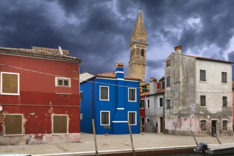 Colourful residential buildings, behind the leaning tower of the church of St. Martin Vescovo, 16th