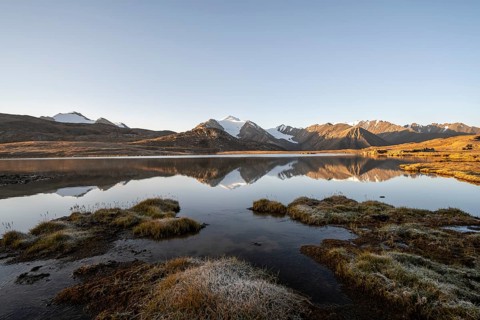 Glaciated mountain peaks reflected in a mountain lake at sunset, Arabel Lake at Arabel Pass, Issyk