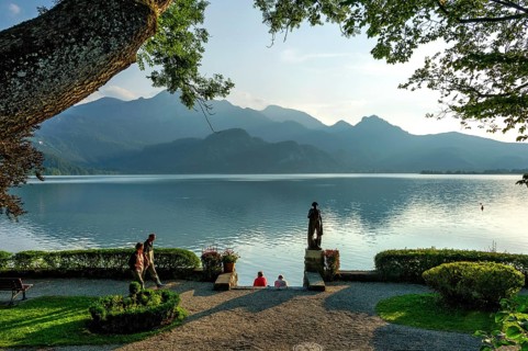 Strollers in the evening light, lakeside promenade with the fisherman statue by Richard Miller,