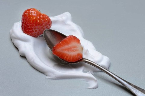 Strawberries with cream on a spoon