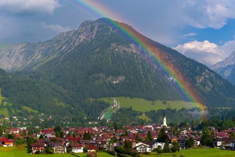 View over Oberstdorf with rainbow, behind it the Schattenberg, 1845m, OberallgÃ¤u, Bavaria,
