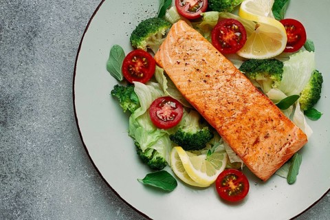 Grilled salmon fillet, with vegetables, broccoli, cherry, iceberg lettuce, spices and herbs,