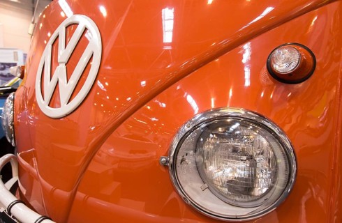 The front end of a Volkswagen bus with large VW logo, indicators and headlights. Techno Classica is