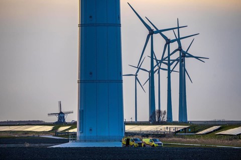 Windmill Poldermolen De Goliath stands between the high-tech wind turbines in Eemshaven, historic