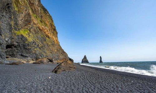 Black beach with cliffs, rock Reynisdrangar in the water, at Reynisfjara beach, Vik, South Iceland,