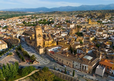 Aerial view of a city with historic church in the centre, surrounded by buildings and landscape,