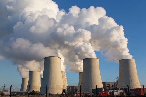 Steam rises from the cooling towers of the Vattenfall power plant in JÃ¤nschwalde, power lines and