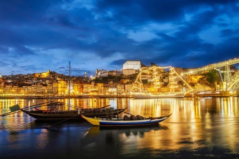 View of Porto city and Douro river with traditional boats with port wine barrels and sailing ship