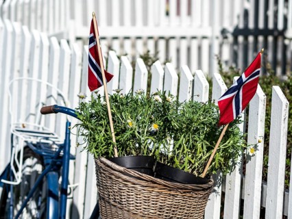 Decorated bicycle at a white fence, norwegian national day, village Solvorn at the Sognefjord,