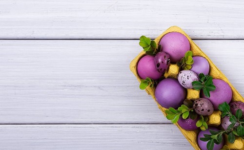 Easter eggs, purple and lilac, on a white wooden table, Easter card, banner, selective focus,