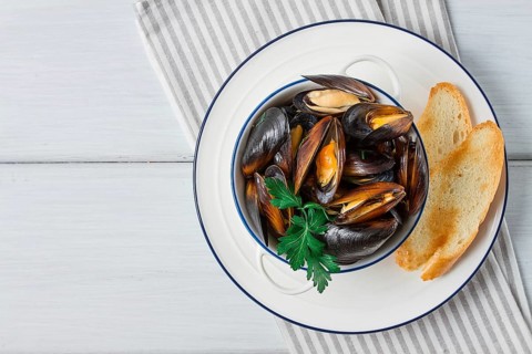Fresh, Boiled mussels, Black Sea, with white bread, on a white wooden table, no people