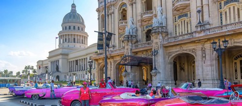 Havana, Cuba â€“ 16 December, 2019: Vintage colorful taxis waiting for tourists close to National