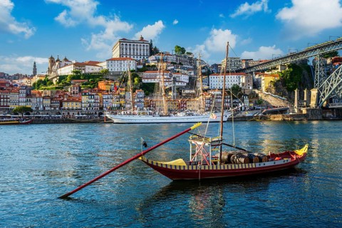 View of Porto city and Douro river with traditional boats with port wine barrels and sailing ship