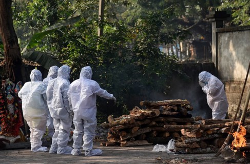 Family members wearing PPE kit performing last rites of a person who died of COVID-19 coronavirus