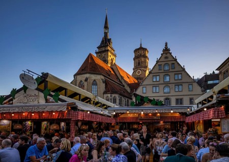 People sitting in wine arbours in the evening, Weindorf Stuttgart, Schillerplatz, collegiate