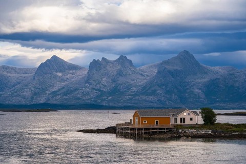 Boathouse on the shore, the Seven Sisters mountain range behind, Heroy island, Helgeland coast,