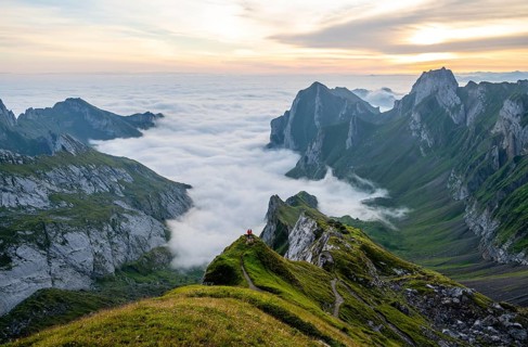 Two hikers enjoying the view over the SÃ¤ntis mountains into the valley of Meglisalp at sunrise,