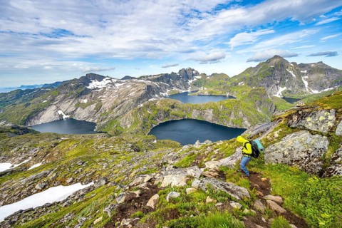 Mountaineers on a hiking trail, mountain landscape with steep rocky mountain peaks and lake