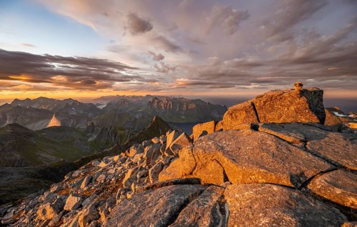 View over mountain top and sea, dramatic sunset, at the top of Hermannsdalstinden, Moskenesöy,