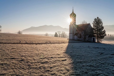 Church backlit with sun in front of mountains, winter, fog, hoarfrost, Sankt Johannisrain,