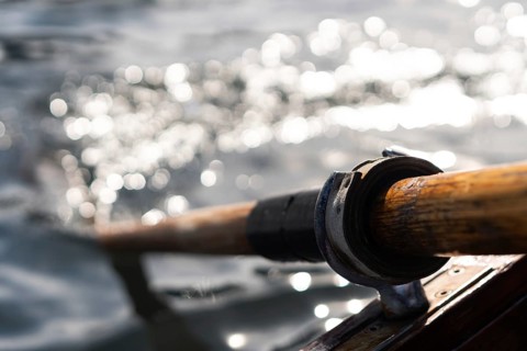 Closeup photo of wooden paddle used for rowing in the water, lake Bled