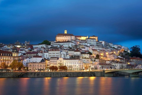 Coimbra city view at night with Mondego river and beautiful historic buildings, in Portugal