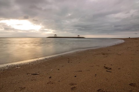 Beautiful seascape in the morning. Tropical sandy beach with breakwater and reflection of the sky
