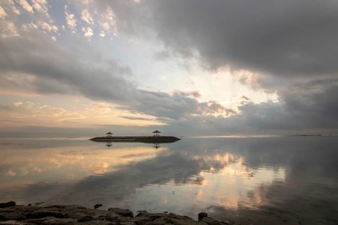 Beautiful seascape in the morning. Tropical sandy beach with breakwater and reflection of the sky