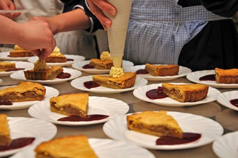 Cooks adding cream to delicious homemade apple pies