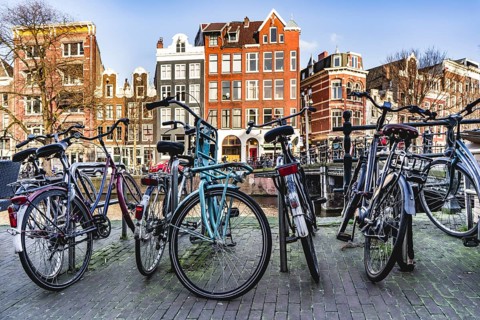 Bicycles parked near a canal in Amsterdam city