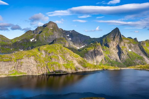 Mountain landscape with lake Tennesvatnet, at sunrise, in the back peak of Hermannsdalstinden,
