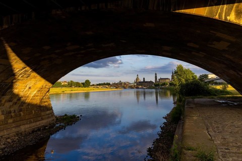 View through the arches of the Marienbrücke onto the Elbe meadows in Dresden's Old Town with