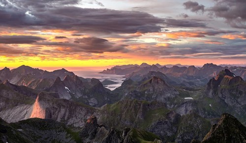 View over mountain top and sea, dramatic sunset, from the top of Hermannsdalstinden, Moskenesöy,