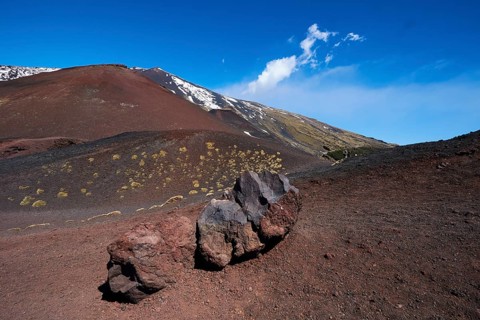 Red lava rocks, red lava earth, snow-capped peak, blue sky, white clouds, Crateri Silvestri, Etna,