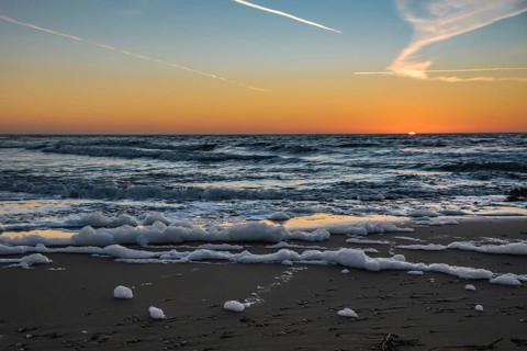 Den Helder, Netherlands. January 2022. Setting sun on the beach of Den Helder, Netherlands.