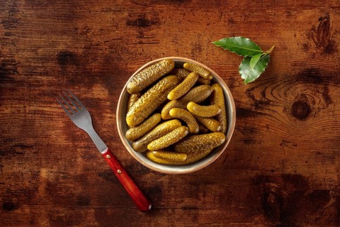 Pickled cucumbers with bay leaf. Fermented food. Homemade canned gherkins. Top shot on a rustic