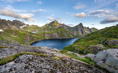 Mountain landscape with lake Tennesvatnet, at sunrise, in the back peak of Hermannsdalstinden,