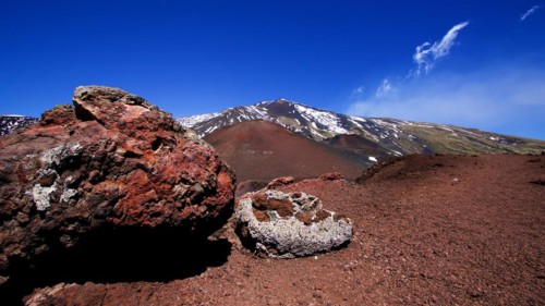 Large red lava boulder, red lava earth, snow on summit, Crateri Silvestri, Etna, volcano, Eastern