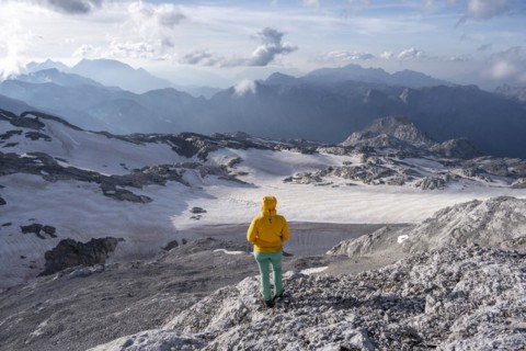 High alpine landscape, snowfields and rock, hiker Looking down into the valley from the Hochkönig,