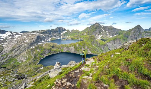 Mountaineers on a hiking trail, mountain landscape with steep rocky mountain peaks and lake