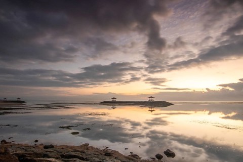 Beautiful seascape in the morning. Tropical sandy beach with breakwater and reflection of the sky