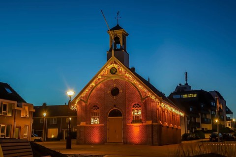 Den Helder, the Netherlands. December 2021. Kerkje van Huisduinen with Christmas lights during the